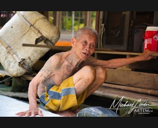 Thailand Mae Klong - Tätowierter Mann vom schwimmenden Markt